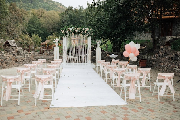 Photo a wedding ceremony is taking place in a garden with a white archway