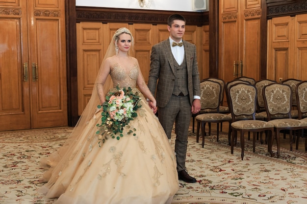 A Wedding ceremony. Registry office. A newly-married couple signs the marriage document.Young couple signing wedding documents.