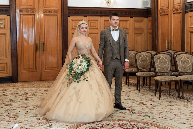 A Wedding ceremony. Registry office. A newly-married couple signs the marriage document.Young couple signing wedding documents.