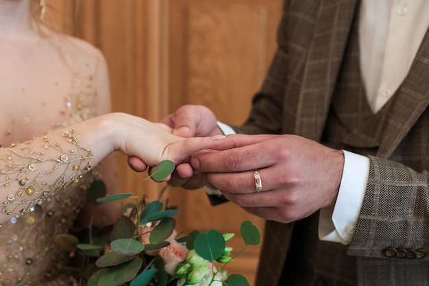 A Wedding ceremony. Registry office. A newly-married couple signs the marriage document.Young couple signing wedding documents.