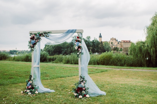 Photo wedding ceremony on the street on the green lawn.decor with fresh flowers arches for the ceremony.