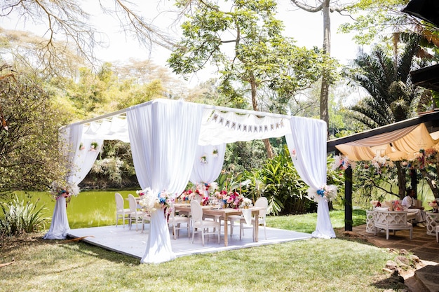 Photo a wedding ceremony with a table and chairs and a tent with the words  brides  on it