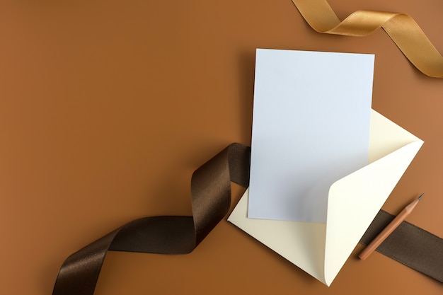 A wedding concept. Wedding Invitation on brown background with ribbon.