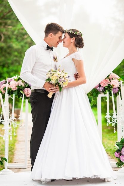 Wedding couple under the flower arch at the wedding ceremony