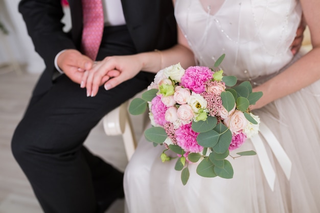 Wedding couple holding hands on summer green background