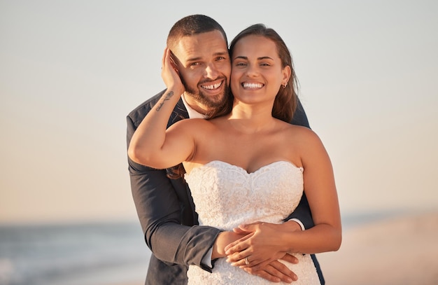 Wedding couple and hug on beach marriage celebration of love support and commitment on Bali honeymoon vacation Portrait of married man and woman celebrate joy and happiness on Hawaii sea holiday