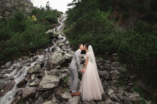 Wedding couple kissing near the lake in Tatra mountains in Poland, Morskie Oko 