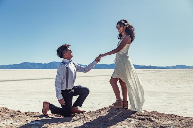 Wedding couple posing in white landscape with dress and suit