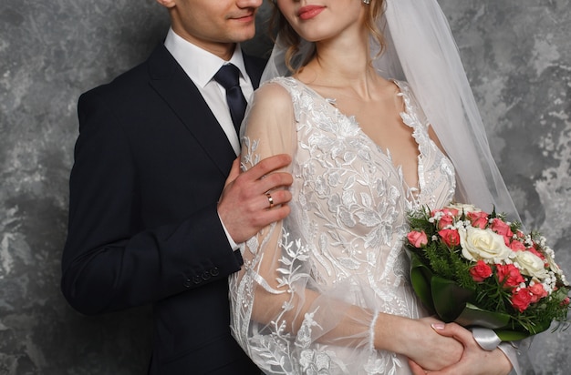 wedding day. newlyweds kissing during the marriage ceremony. passionate hugs of a loving couple. groom with buttonhole gently hugging the bride with pink bouquet. wedding romantic moment. just married