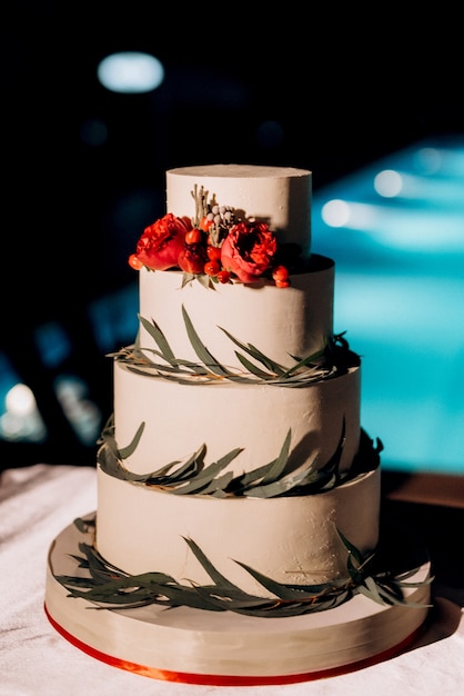 Wedding decor with cake on a wooden bench against a waterfall background