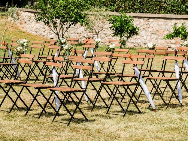 Photo wedding decoration chairs in rustic green style wedding ceremony outdoors