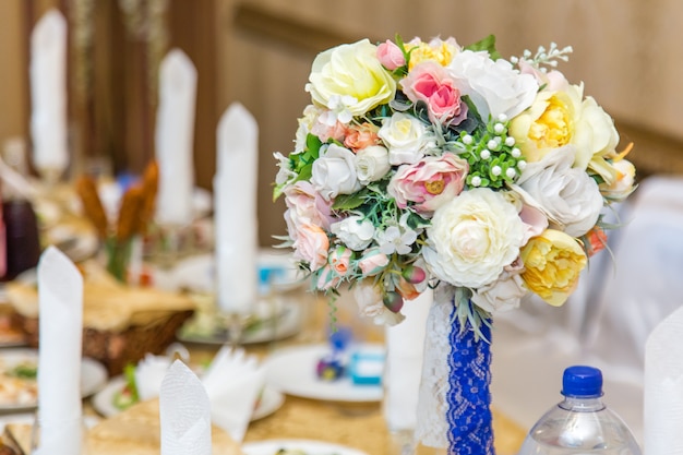 Wedding decorations bouquets of roses on a table in restaurant interior.