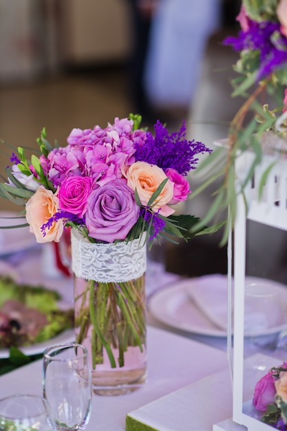 Wedding dinner in the restaurant, tables decorated with vases of roses.