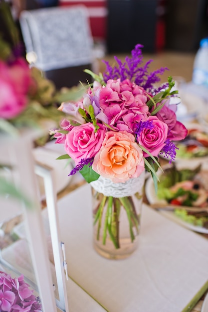 Wedding dinner in the restaurant, tables decorated with vases of roses.