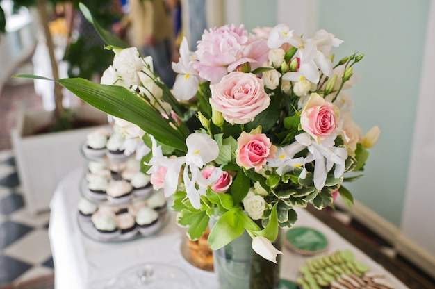 Wedding dinner in the restaurant, tables decorated with vases of roses.