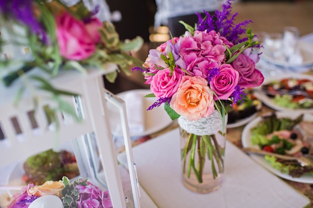 Wedding dinner in the restaurant, tables decorated with vases of roses.