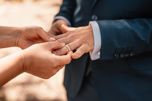 Wedding engagement rings Married couple exchange wedding rings at a wedding ceremony Groom put a ring on finger of his lovely wife