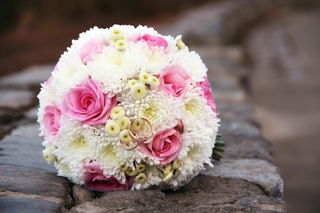 Wedding gold rings with bridal flower bouquet