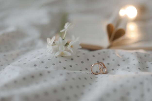 Wedding golden ring and open book with folded sheets in heart shape Wedding concept Valentines Day