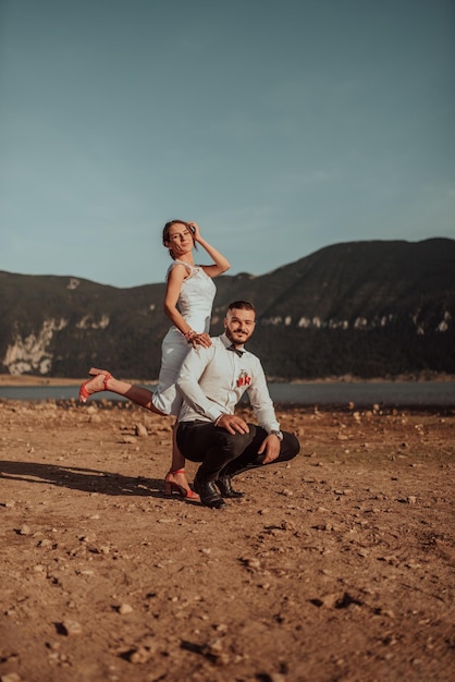 Wedding photo. A young married couple having fun and dancing by a large lake.Selective focus. High quality photo