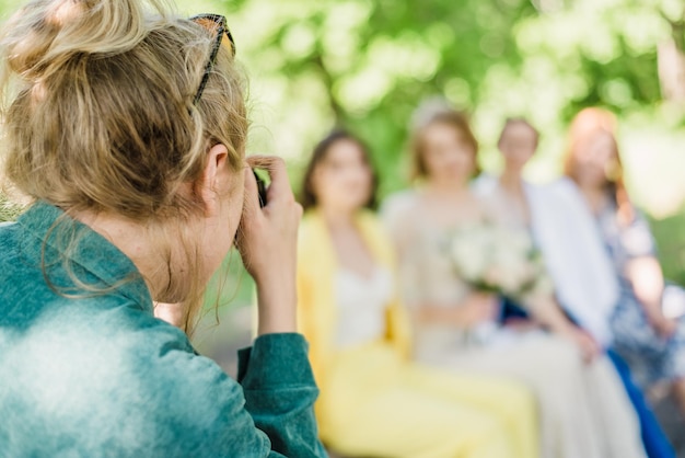 The wedding photographer photographs the guests of the bride and groom in nature