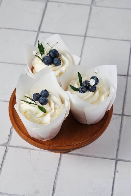 Wedding preparations White wedding cupcakes decorated with fresh blueberries herbs and flowers