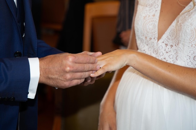 Wedding Ring in groom man hand put on Bride woman finger in marriage day