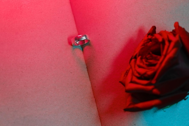 Wedding ring in open book with empty pages and heartshaped shadow Concept of Valentine's Day