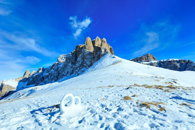 Wedding ring sculpture from the snow on winter mountain slope (Sella Pass , Italy).