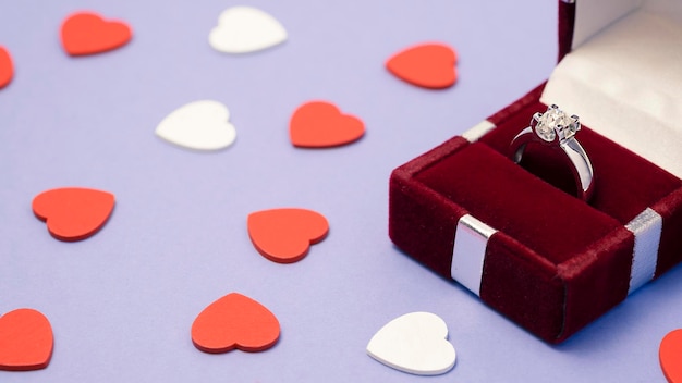 Wedding rings in a gift box with hearts on violet background