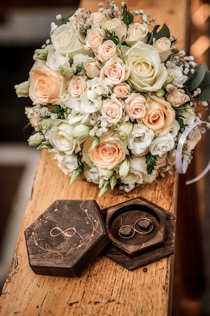 Wedding rings lie on a beautiful box near bridal bouquet