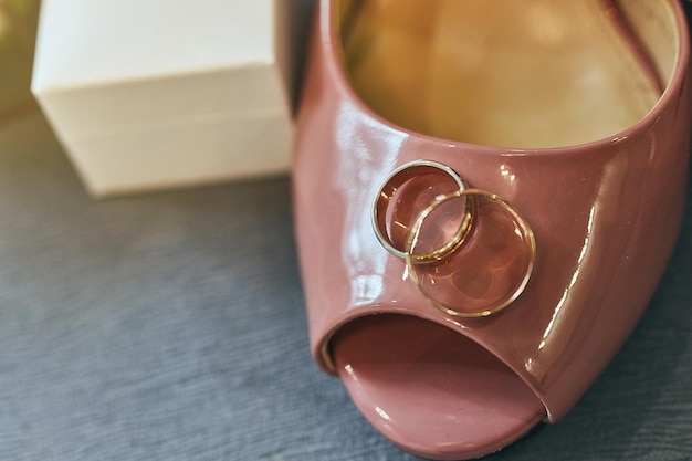 Wedding rings lie on a beautiful shoes as bridal accessories