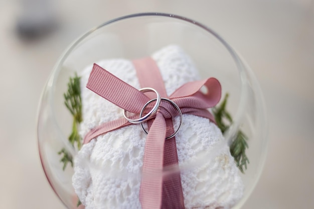 Wedding rings lie in a beautiful vase