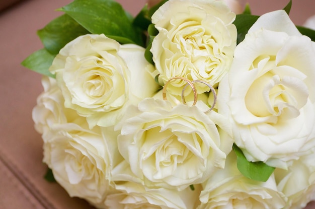 Wedding rings lie on a bouquet of roses