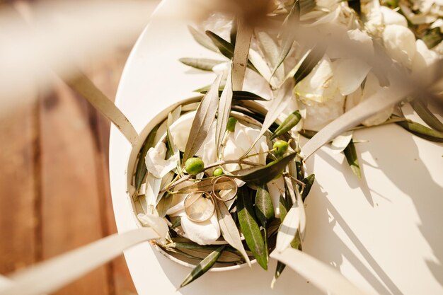 Wedding rings in olive leaves macro background