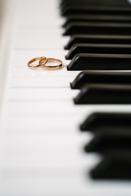 Wedding rings on the piano keys golden wedding rings lie on the piano free space for text