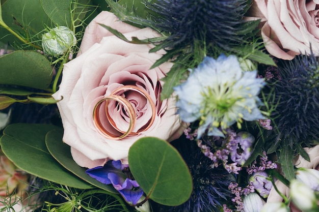 Wedding rings on a rose in the bride's bouquet