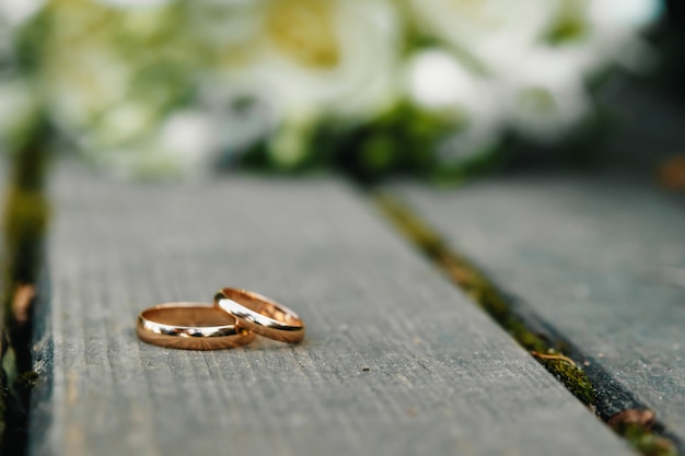 Wedding rings with bridal bouquet lying on the morning of the bride.