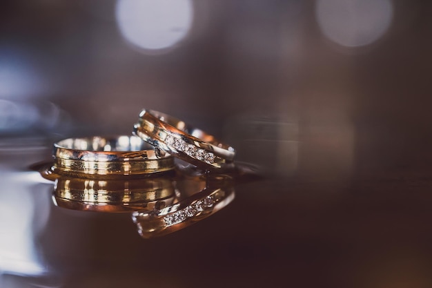 Photo wedding rings on a wooden box with shadows of leaves