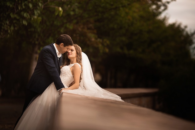 Wedding shot of bride and groom in park. Romantic scene in the park