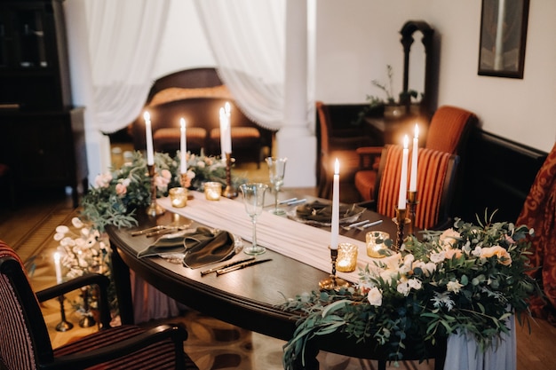 Wedding table decoration with flowers on the table in the castle, table decor for dinner by candlelight.Dinner with candles.