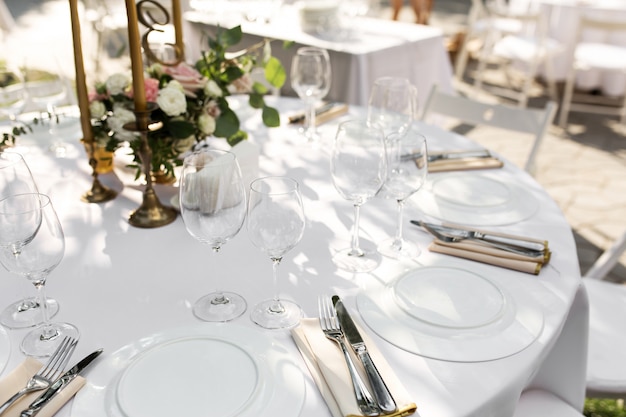 Wedding table setting decorated. Banquet table for guests outdoors with a view of green nature