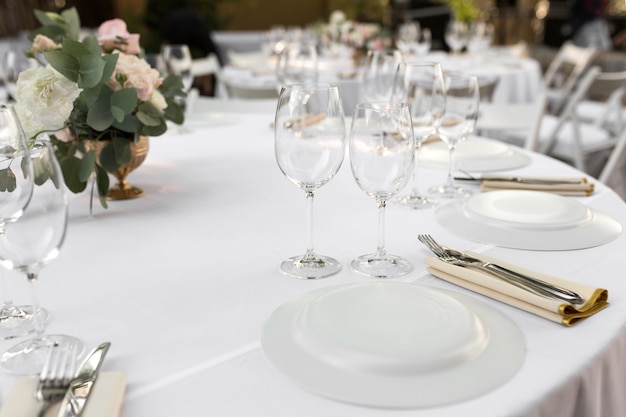 Wedding table setting decorated with fresh flowers in a brass vase