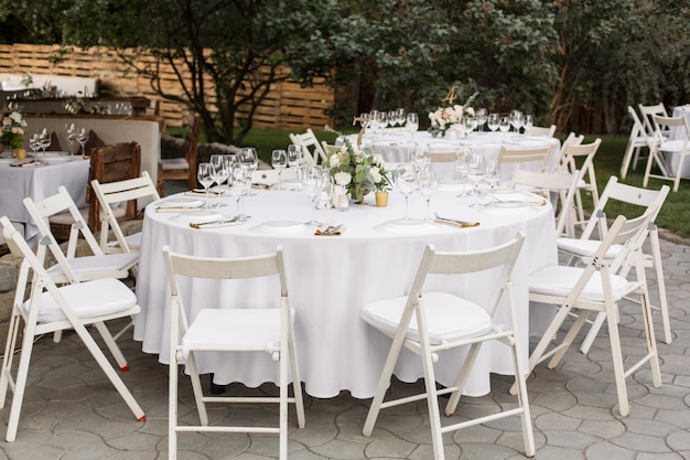 Wedding table setting decorated with fresh flowers in a brass vase