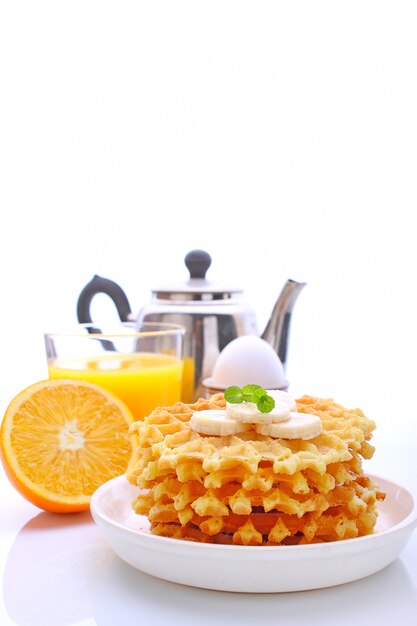 Weekend breakfast: waffles with banana decorated with mint, egg, orange juice. 