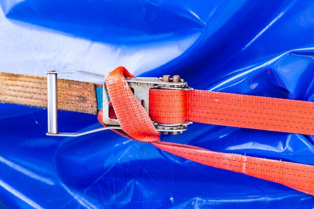 A weight belt with a ratchet lock holds the load wrapped in blue tape