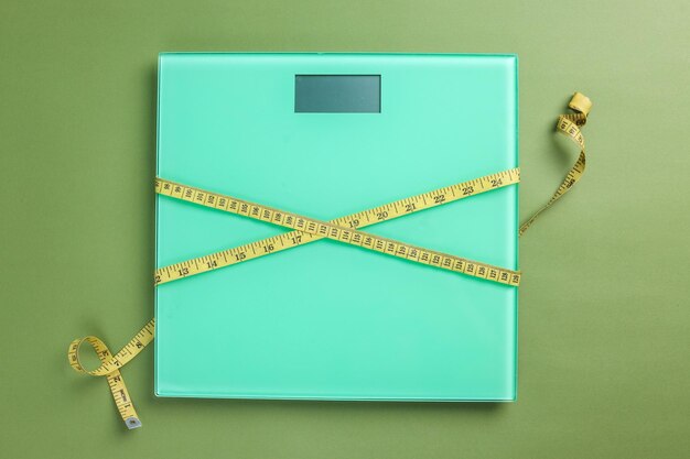 Photo weight scale with a measuring tape on green background