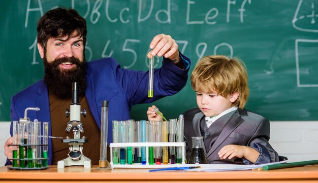 Welcome back to class training room with blackboard small boy with teacher man Wisdom Back to school son and father at school Flask in scientist hand with Test tubes