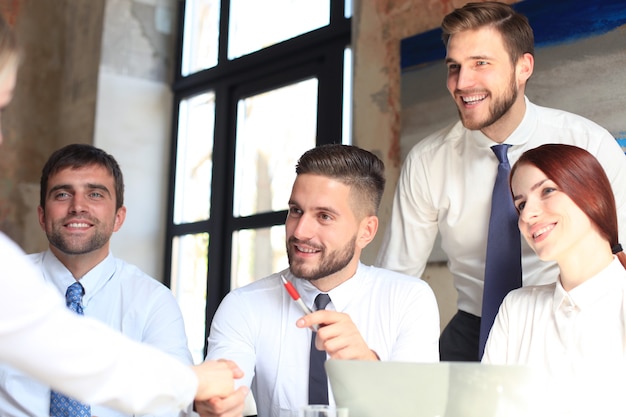 Welcome to our team. Young modern businessmen shaking hands while working in the creative office.