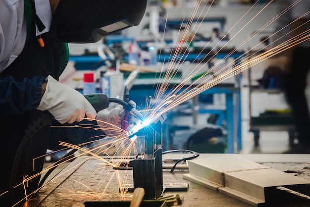 welder is welding the metal parts in the automobile assembly plant and practicing the skills of the welder in industrial plants.